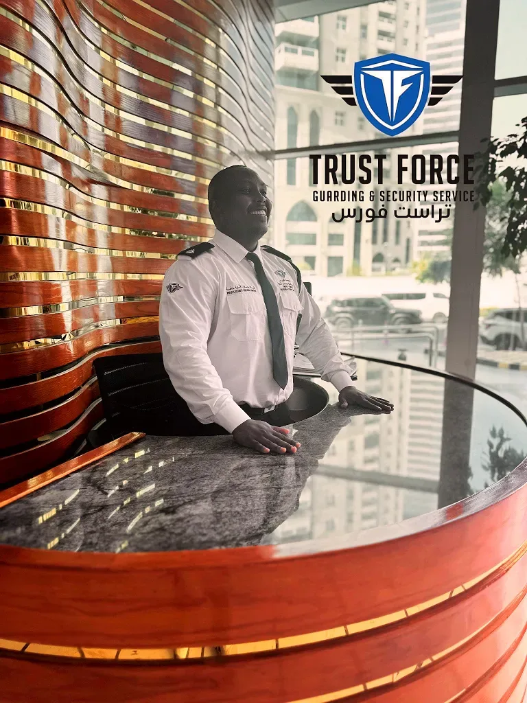 A TrustForce security guard on duty at a corporate reception desk in Doha — managing visitor access, maintaining a professional front-of-house presence, and ensuring a secure and welcoming environment for employees and guests.