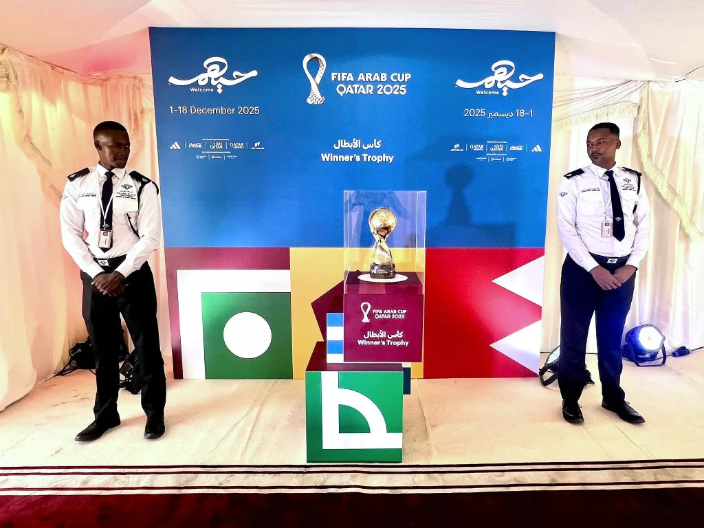 Two MOI-certified TrustForce Security guards stand on duty beside the FIFA Arab Cup 2025 Winner’s Trophy during the official display event in Doha, Qatar, organized by DOT Vision and FIFA.