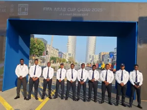 A professionally uniformed security team standing in formation at Lusail Boulevard, Doha, in front of the FIFA Arab Cup Qatar 2025 installation
