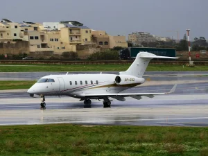 White private jet on a wet runway ready for departure — charter evacuation flight from the Gulf region coordinated by TrustForce Security