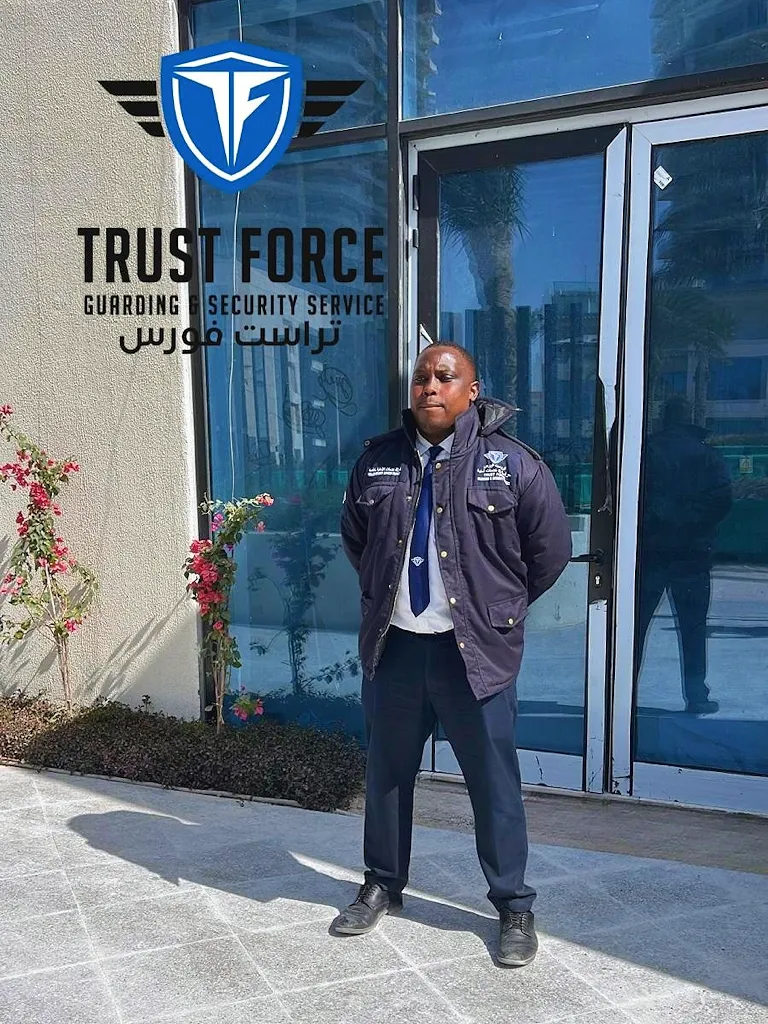 Uniformed TrustForce security guard standing at the entrance of a hotel or hospitality venue in Qatar