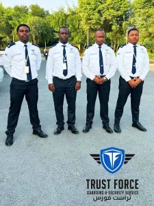 Four uniformed TrustForce security guards standing on duty at a retail or commercial location in Qatar