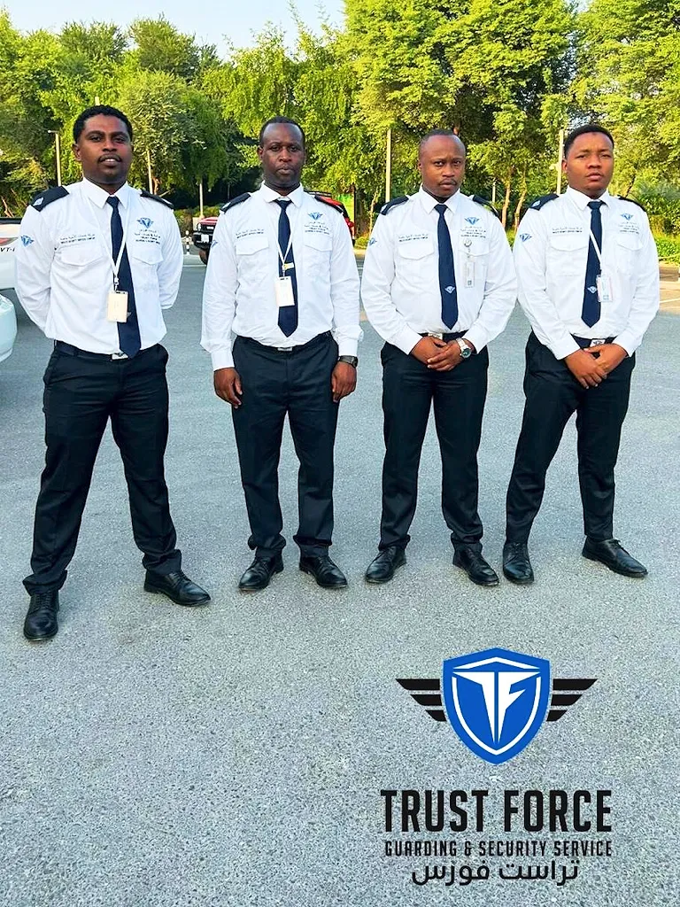 Four uniformed TrustForce security guards standing on duty at a retail or commercial location in Qatar