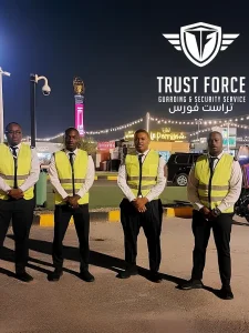 Four TrustForce security guards in high-visibility vests on duty at a public entertainment venue in Doha, Qatar